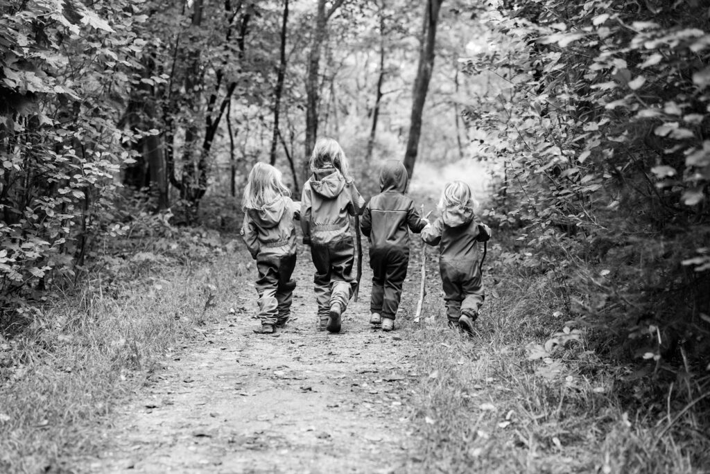 4 Kinder laufen in den Wald