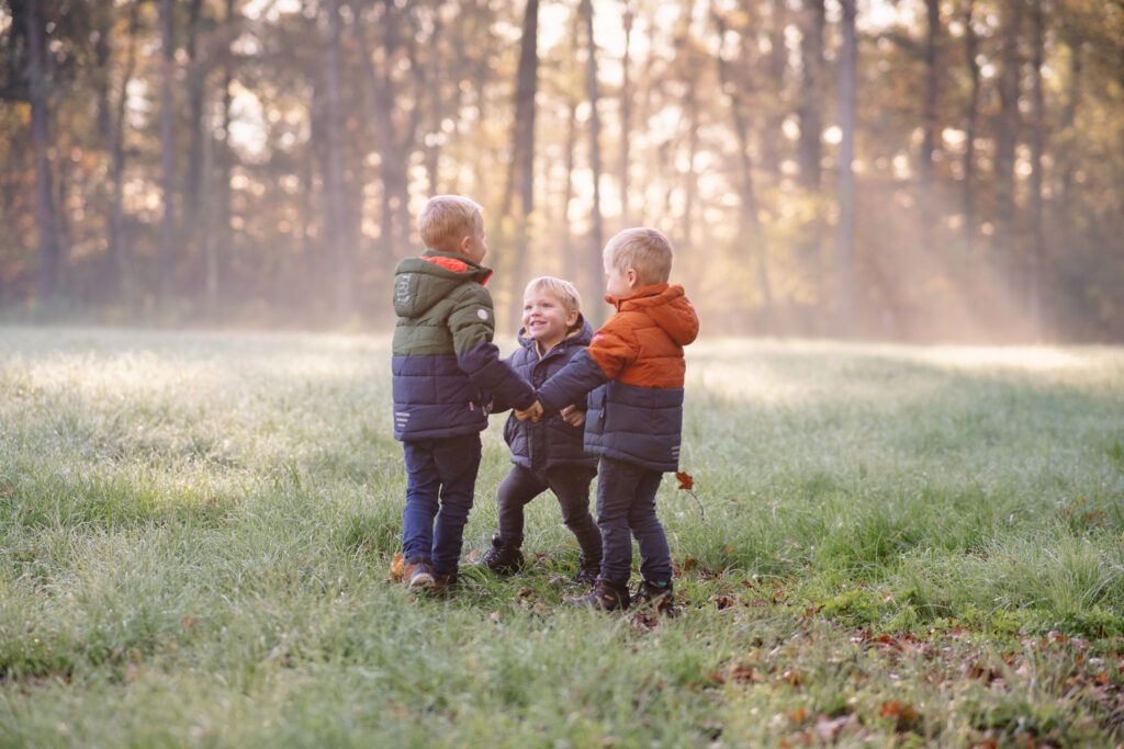 Drei Kinder spielen auf einer Wiese